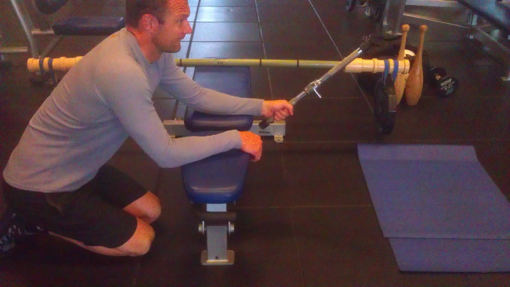 A kart racer training with a lat pull-down hand grip as a weight for wrist flexion/extension training