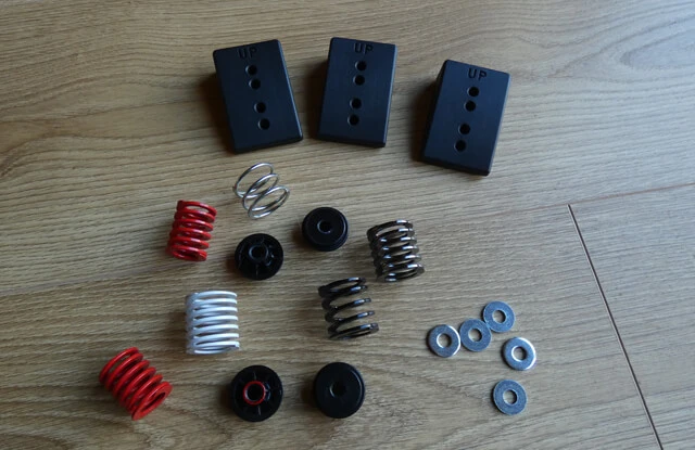 Thrustmaster T-LCM spare brake pedal springs, washers and pedal face spacers on a wooden floor.