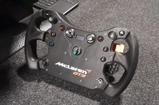 Fanatec CSL Elite McLaren GT3 V2 sim racing wheel on its own with a gray background.