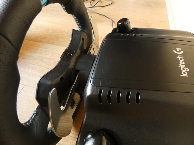 Logitech G29 sim racing wheel from behind, showing the metal paddle shifters on the back of the wheel rim.