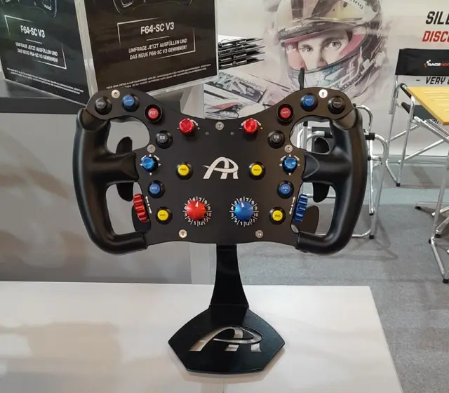 Ascher Racing F64 V3 sim racing wheel rim on a display stand on a table.