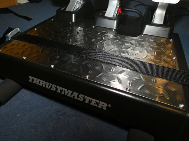 Thrustmaster T-LCM sim racing pedals strapped down to the mount of the Playseat Challenge.