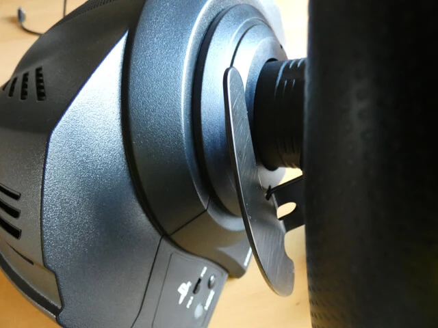 The back of the Thrustmaster T300 RS sim racing wheel showing the wheel base and the metal paddle shifters.