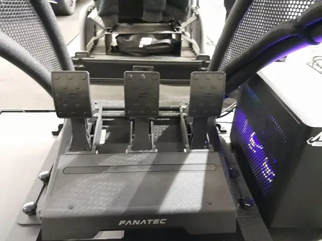 Fanatec CSL Elite V2 sim racing pedals next to a sim racing PC.