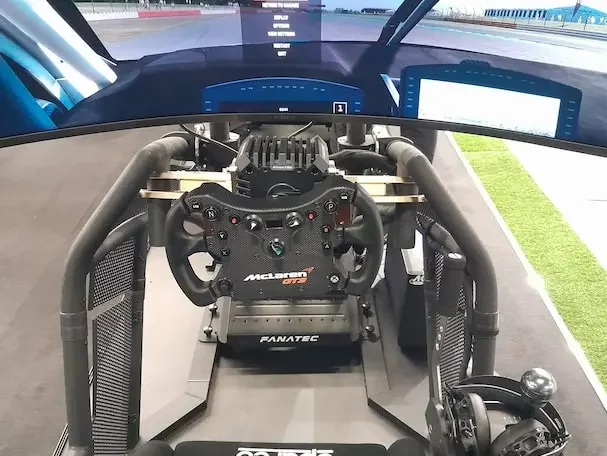 Fanatec McLaren GT3 V2 sim racing wheel rim connected to a CSL DD direct drive wheel base on a Rennsport V2 cockpit.