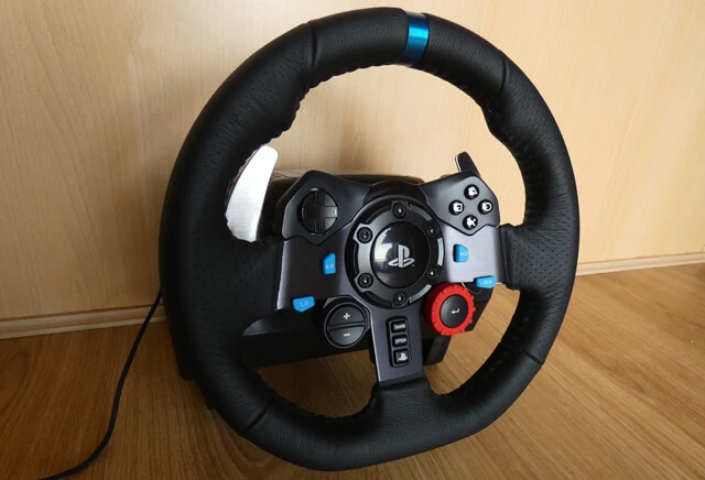 Logitech G29 sim racing wheel with a wooden background.