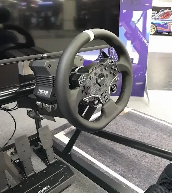 MOZA R5 bundle with the MOZA R5 sim racing wheel base connected to an ES wheel with the SR-P Lite pedals in the background.