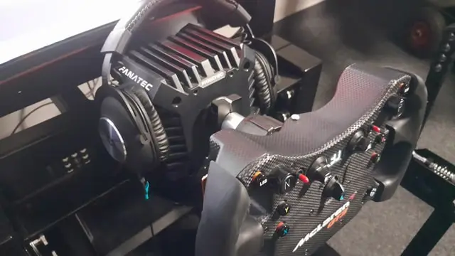 Fanatec CSL Elite McLaren GT3 wheel rim attached to CSL DD wheel base with a pair of Logitech headphones.