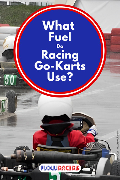 Several go-kart drivers racing on a wet track with barriers on either side of the racing surface, all of them are equipped with wet tires, What Fuel Do Racing Go-Karts Use?